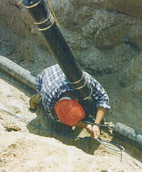 Electrician pulling in low wattage THERMOCABLE® electric tracing cable on a pre-insulated 25 mm (1 in) service pipe and curbstop assembly in northern Ontario.